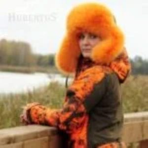 May include: An orange fur hat with ear flaps and a matching orange and black camouflage jacket. The jacket has a dark green base color. The image is taken outdoors with a blurred background of a lake and trees.