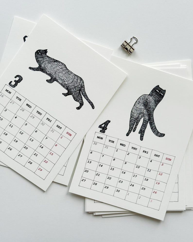 May include: A stack of white paper calendar pages featuring black ink illustrations of cats. One page shows the number 3 with a cat in motion, and another shows the number 4 with a standing cat. Each page includes a grid of days and dates.