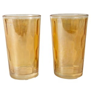 Puede incluir: Dos vasos de vidrio ámbar con un diseño texturizado y facetado. Los vasos están vacíos y tienen un ligero brillo.