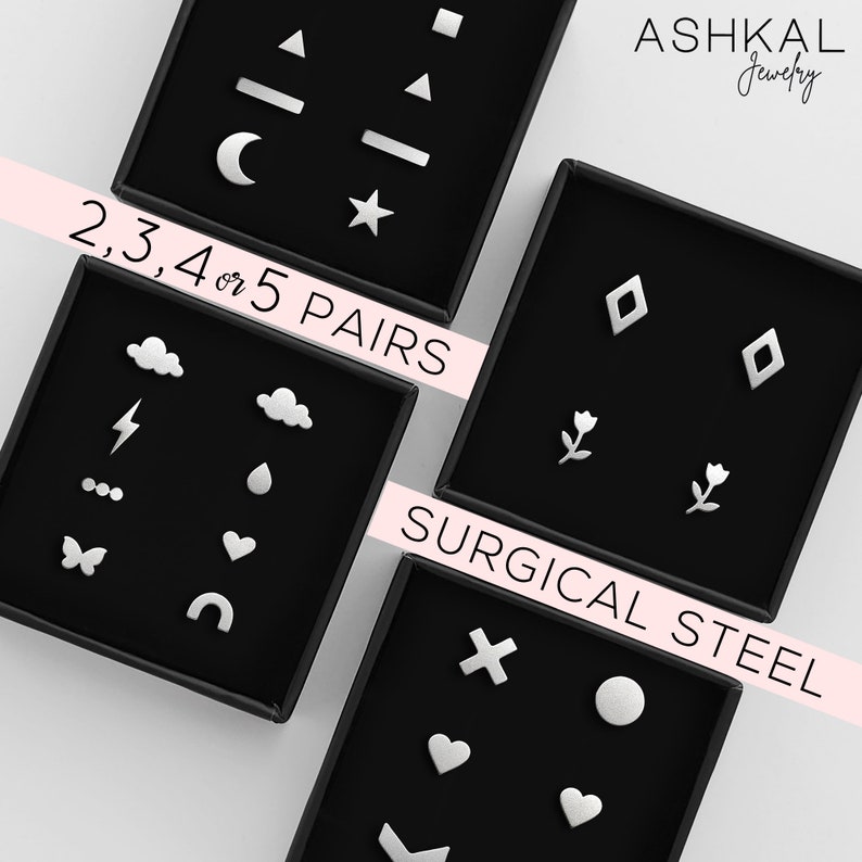 May include: Three black boxes with different sets of silver earrings. The earrings are in the shapes of stars, moons, clouds, lightning bolts, hearts, butterflies, diamonds, flowers, and more. The boxes are labeled "2, 3, 4 or 5 PAIRS" and "SURGICAL STEEL".