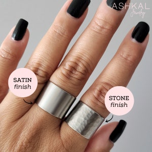 May include: Two silver rings on a hand, one with a smooth satin finish and the other with a hammered stone finish. The rings are labeled "SATIN finish" and "STONE finish".
