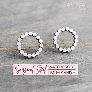 May include: A pair of silver surgical steel earrings with a circle design. The earrings are waterproof and non-tarnish.
