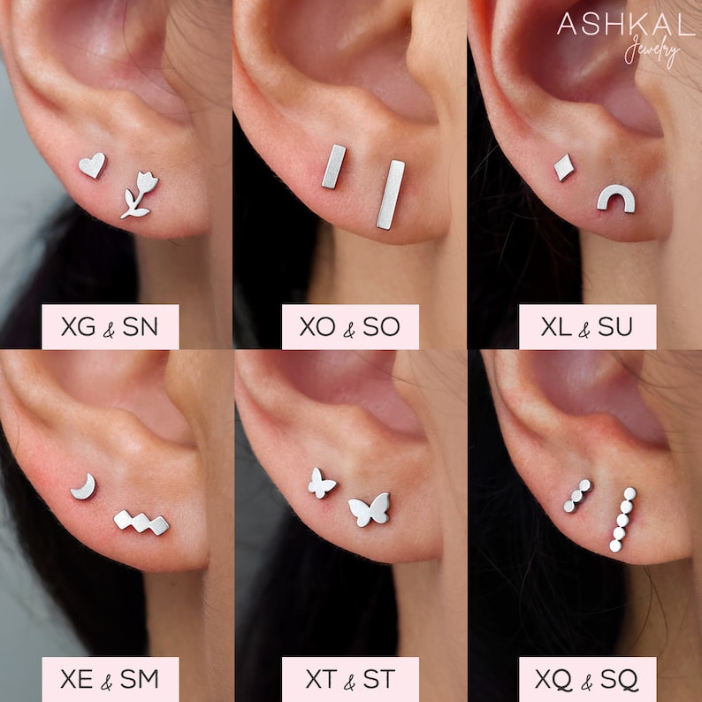 May include: Nine different pairs of silver earrings with various designs, including a heart, flower, bar, diamond, crescent moon, butterfly, and a row of dots. The earrings are displayed on a model's earlobes.