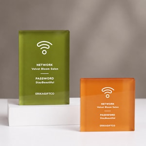 May include: Two rectangular acrylic signs with white text and icons. The taller olive green sign and the shorter orange sign both display a Wi-Fi symbol, the text NETWORK Velvet Bloom Salon, the text PASSWORD StayBeautiful, and ERIKAGIFTCO.