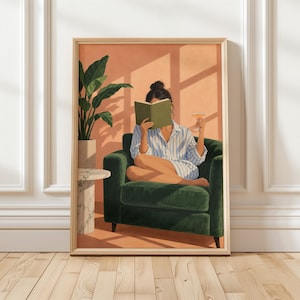 Op de afbeelding: Een ingelijste kunstdruk toont een persoon in een donkergroene fluwelen fauteuil, lezend in een groen boek en met een glas wijn. De persoon draagt een blauw-wit gestreept overhemd. Een kamerplant staat op een bijzettafel van marmer.