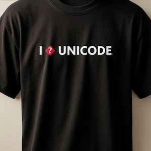 Puede incluir: Una camiseta negra de manga corta con el texto blanco "I" seguido de un rombo rojo que contiene un signo de interrogación blanco, y la palabra "UNICODE" en letras mayúsculas blancas impresa en el centro del pecho.