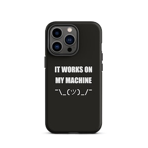 May include: Black phone case with a triple-lens camera cutout. The case features the white text "IT WORKS ON MY MACHINE" and a smiley face emoticon.