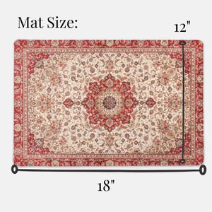 May include: Rectangular rug with a cream-colored field and a central red medallion. The rug has a red border and intricate floral patterns. The mat measures 18 inches by 12 inches.