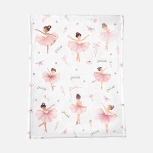 May include: White blanket featuring a pattern of pink ballerinas in various poses. The design includes butterflies, bows, flowers, and the name "Delilah" in a script font. The ballerinas wear pink tutus and have their hair in buns.