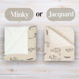 Puede incluir: Dos mantas dobladas con fondo beige y un patr&oacute;n repetitivo de aviones y alas dibujados con l&iacute;neas negras. Una manta tiene el reverso blanco liso, mientras que la otra presenta un patr&oacute;n de tejido jacquard texturizado de color crema.