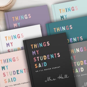 A selection of custom teacher gifts notebooks in shades like black, purple, and teal. Each notebook displays the text "THINGS MY STUDENTS SAID" in colourful lettering. These notebooks are designed for teachers to record student quotes.