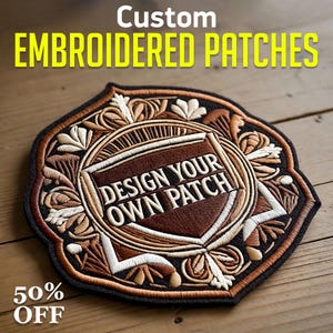 Puede incluir: Parche bordado personalizado con un diseño de escudo. El parche presenta el texto "DESIGN YOUR OWN PATCH" en blanco, rodeado de intrincados bordados marrones, beige y blancos. El parche está sobre una superficie de madera. El texto "50% OFF" está en la parte inferior.