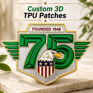 Könnte beinhalten: Ein individueller 3D-TPU-Patch mit dem Text "Custom 3D TPU Patches" und "FOUNDED 1948". Der Patch zeigt ein grünes "75"-Design mit einem Adler und einem Schild mit roten und weißen Streifen und Sternen. Der Patch hat einen silbernen und goldenen Rand.