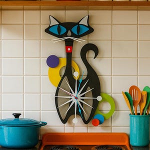 May include: A black cat-shaped wall clock featuring bright blue eyes, white whiskers, and a red collar. The clock face is a white starburst design with thin hands. It is decorated with yellow, purple, green, and red circular accents on the sides.