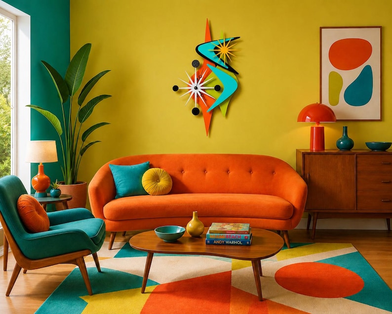 Op de afbeelding: Een wandklok in stervorm met een witte wijzerplaat en zwarte wijzers, omringd door oranje en turquoise boemerangvormige accenten, een geel zonnestraalelement en zwarte cirkelvormige markeringen in een gelaagd ontwerp.