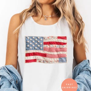 Könnte beinhalten: Weißes Tanktop mit einem Patchwork-Design der amerikanischen Flagge. Die Flagge enthält blaue Jeanssterne, rot-weiß gestreiften Stoff und Stoff mit Blumenmuster. Das Tanktop ist ärmellos und hat einen runden Ausschnitt.