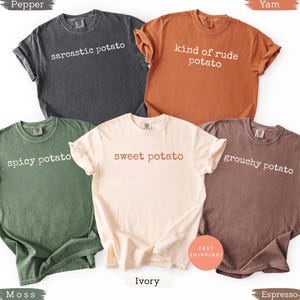 以下が含まれることがあります： さまざまな色の5枚のTシャツ。それぞれ前面に異なるジャガイモをテーマにしたフレーズがプリントされています。色は、濃いグレー、オレンジ、グリーン、アイボリー、ブラウンです。「sarcastic potato」、「kind of rude potato」、「spicy potato」、「sweet potato」、「grouchy potato」のフレーズ。