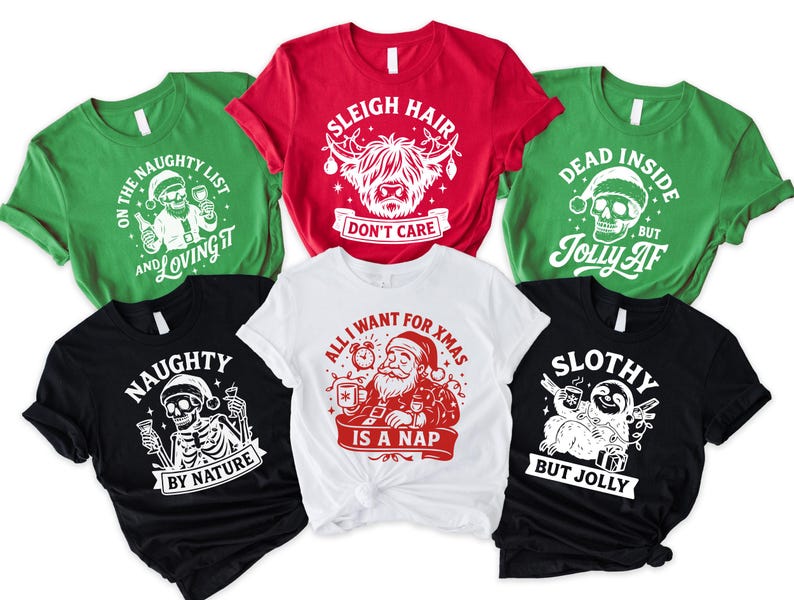 May include: A collection of Christmas-themed t-shirts in various colors, including green, red, black, and white. Each shirt features a unique graphic design with text, such as "Sleigh Hair Don't Care" and "Naughty by Nature".