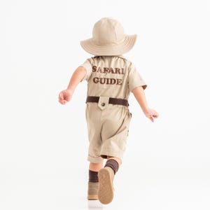 a little boy in a safari outfit running
