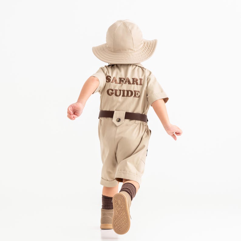 a little boy in a safari outfit running