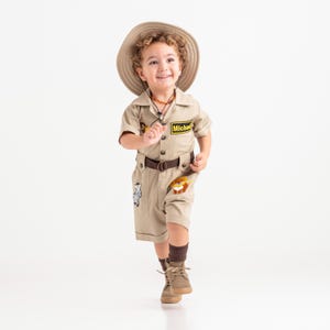 a little boy dressed in a safari outfit