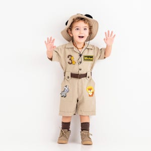 a little boy dressed in a safari outfit
