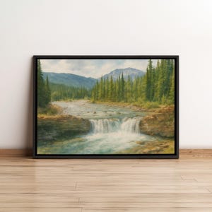 Pode incluir: Pintura de paisagem emoldurada que retrata uma serena cena fluvial. A obra de arte mostra uma cachoeira caindo em um riacho claro e turquesa, cercada por exuberantes árvores verdes e montanhas distantes sob um céu nublado. A moldura é preta.