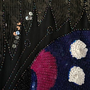 May include: A black fabric with sequins, featuring a butterfly design in shades of blue, pink, and white.