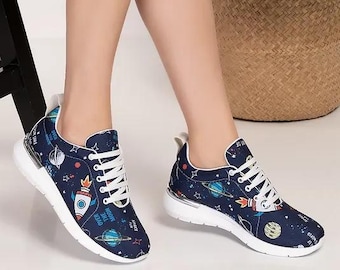 Könnte beinhalten: Marineblaue Sneaker mit Weltraum-Design mit Raketen, Planeten und Sternen. Die Schuhe haben weiße Schnürsenkel und Sohlen. Diese Low-Top-Sneaker eignen sich für den täglichen Gebrauch.