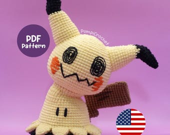 May include: A crocheted Mimikyu plush toy in cream, black, and orange. The toy features black eyes, a jagged mouth, and orange cheek markings. The image includes a "PDF Pattern" graphic and a US flag.
