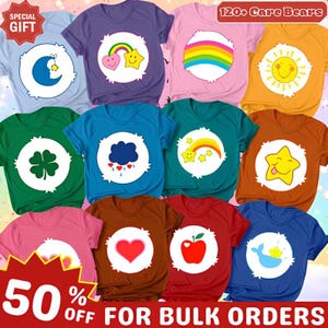 May include: A collection of twelve short-sleeved t-shirts in various colors, each featuring a circular white emblem with a unique Care Bears graphic, including a moon, rainbow, sun, clover, cloud, star, heart, apple, and whale, with text reading 120+ Care Bears.
