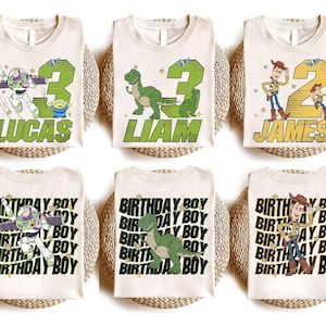 May include: Cream-colored t-shirts featuring Toy Story characters and names. Designs include Buzz Lightyear, Rex, and Woody with age numbers and names like Lucas, Liam, and James. Other shirts say "BIRTHDAY BOY".
