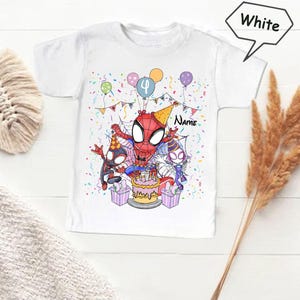 May include: White t-shirt featuring a colorful illustration of Spider-Man celebrating a birthday. The design includes balloons, confetti, a cake, and the number 4. The word "Name" is also visible.