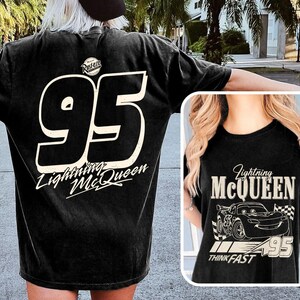 Puede incluir: Camiseta negra con el n&uacute;mero blanco "95" y el texto "Lightning McQueen". La parte trasera tiene el logo "Rust-eze". La parte delantera presenta un dise&ntilde;o de Lightning McQueen y el texto "Think Fast".