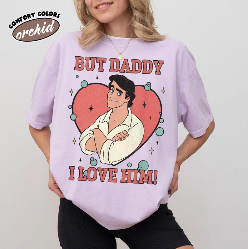 以下が含まれることがあります： 「BUT DADDY I LOVE HIM！」の文字と、ハートの中に男性のイラストが描かれた、オーキッドカラーのComfort Colors Tシャツです。