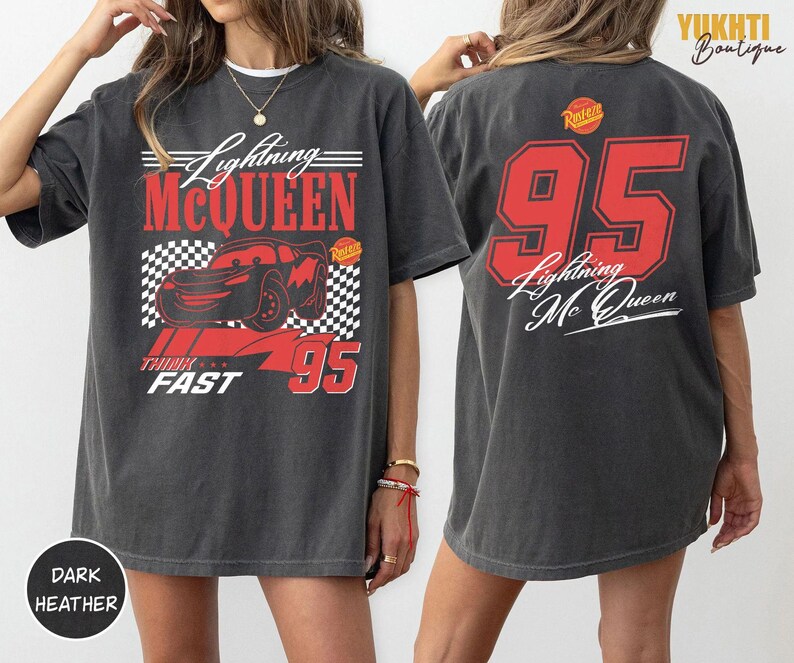 Puede incluir: Camiseta gris oscuro con dise&ntilde;o de Lightning McQueen. La parte delantera muestra el coche, el texto "Lightning McQueen", "Think Fast" y el n&uacute;mero 95 en rojo. La parte trasera tiene un gran 95 rojo y el texto "Lightning Mc Queen".