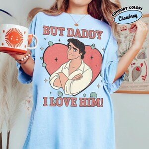 以下が含まれることがあります： 「BUT DADDY I LOVE HIM！」の文字と、ハートの中に漫画の男性が描かれた水色のTシャツ。 ゆったりとしたフィット感で、柔らかい素材で作られています。 Comfort Colorsコレクションの一部です。