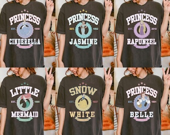 ディズニープリンセス全キャラクターのコンフォートカラーシャツ、ティアナ、アリエル、エルサ、ベル、ラプンツェルのTシャツ、ディズニーグループファミリーシャツ、レトロガールトリップシャツ