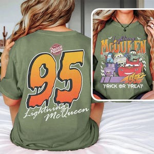 May include: Olive green t-shirt with a large orange and yellow number 95 and "Lightning McQueen" on the back. The front displays a graphic of Lightning McQueen and other Cars characters with the text "Trick or Treat".