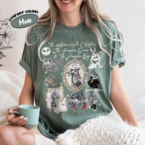 May include: Moss green t-shirt featuring characters from "The Nightmare Before Christmas." The design includes Jack Skellington, Sally, and other characters. The text "The Nightmare Before Christmas & The Pumpkin Queen & The Pumpkin King" is also visible.
