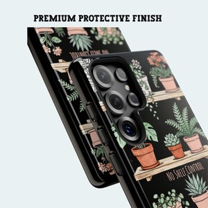 Puede incluir: Funda de tel&eacute;fono negra con un dise&ntilde;o bot&aacute;nico de plantas en macetas sobre estantes. La funda tiene el texto "NO SHELF CONTROL" y "PREMIUM PROTECTIVE FINISH". El dise&ntilde;o incluye plantas verdes y macetas de terracota.