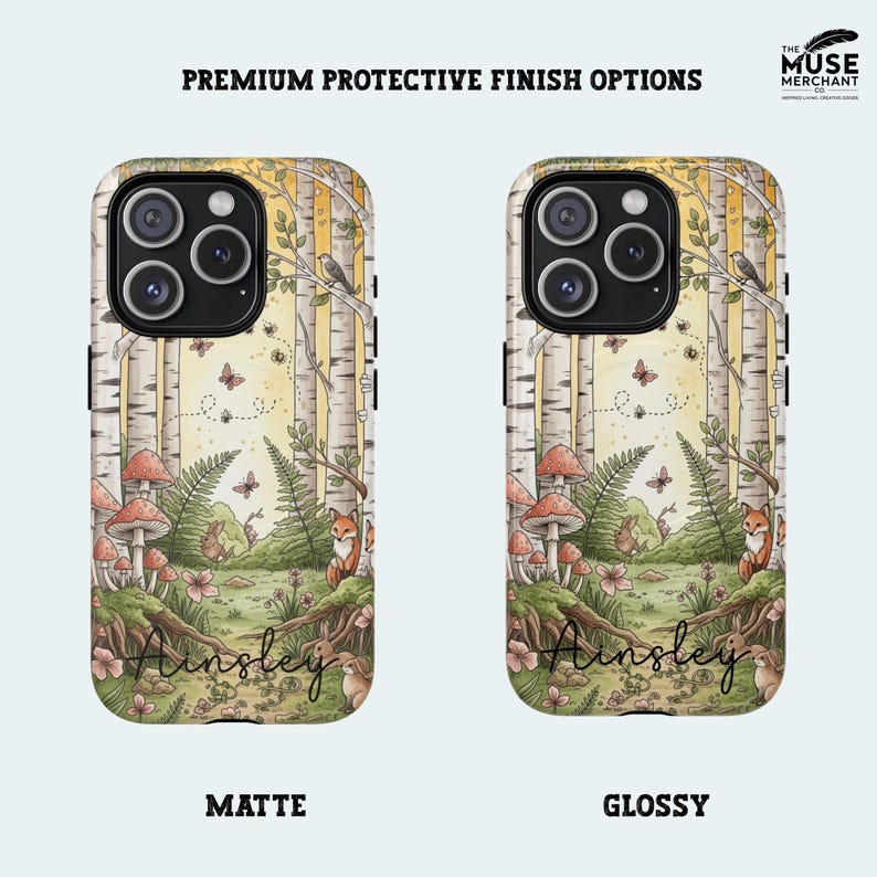 Op de afbeelding: Twee telefoonhoesjes met een bossc&egrave;ne-ontwerp. De hoesjes hebben een berkenbos met paddenstoelen, vossen, vlinders en de naam "Ainsley". Verkrijgbaar in matte en glanzende afwerking. De tekst "Premium Protective Finish Options" staat bovenaan.