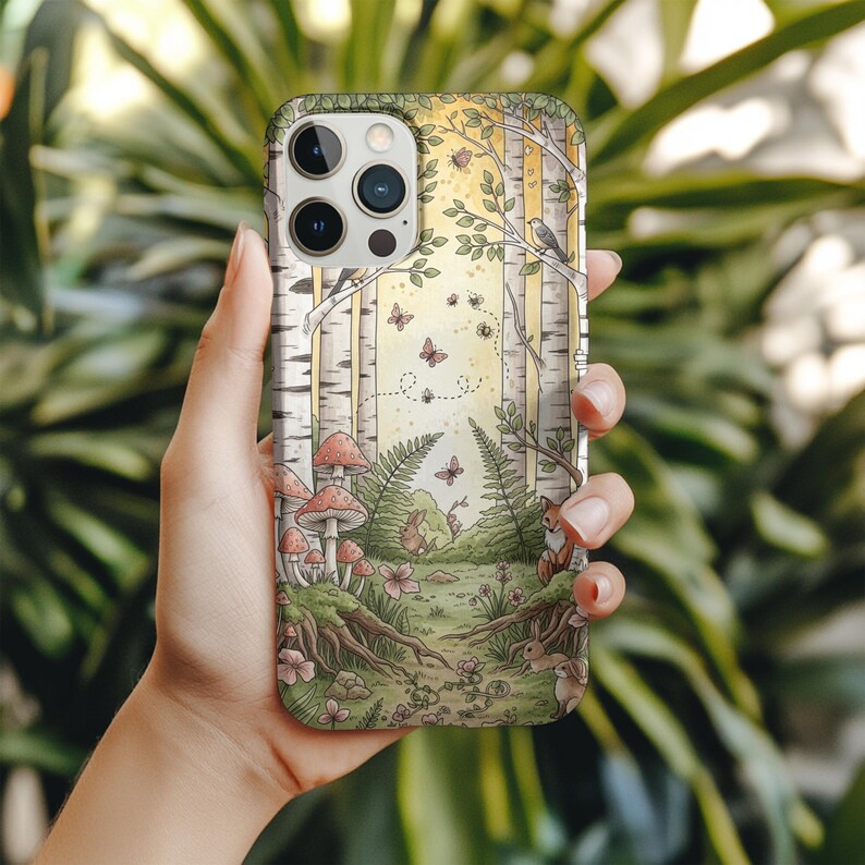 Op de afbeelding: Telefoonhoesje met een bosillustratie, met berken, paddenstoelen, vlinders en een vos. Het gedetailleerde ontwerp maakt gebruik van een zacht kleurenpalet en cre&euml;ert een op de natuur ge&iuml;nspireerd thema.
