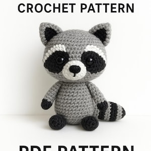 May include: A crocheted raccoon toy in shades of gray, black, and white, with a striped tail and black button eyes. The text "RACCOON CROCHET PATTERN" and "PDF PATTERN" are displayed above and below the raccoon.