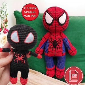 Może przedstawiać: Dwie szydełkowe lalki Spider-Mana. Jedna jest czerwono-niebieska z czarnym emblematem pająka, druga czarna z czerwonymi akcentami. Lalki mają duże białe kształty oczu. Tekst na obrazku brzmi "2 COLOR SPIDER-MAN PDF".