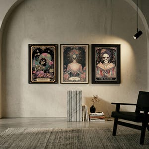 May include: Three framed art prints featuring skeleton figures in a vintage style. The prints are in black frames and have floral and celestial elements. The text on the prints reads "THE DREAMER", "THE STAR", and "THE READER".