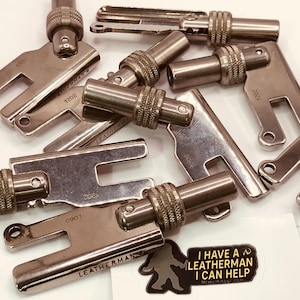 Puede incluir: Una colección de piezas de herramientas Leatherman de color plateado, algunas con la inscripción "LEATHERMAN" y varios números. También se ve una pegatina con el texto "I HAVE A LEATHERMAN I CAN HELP".
