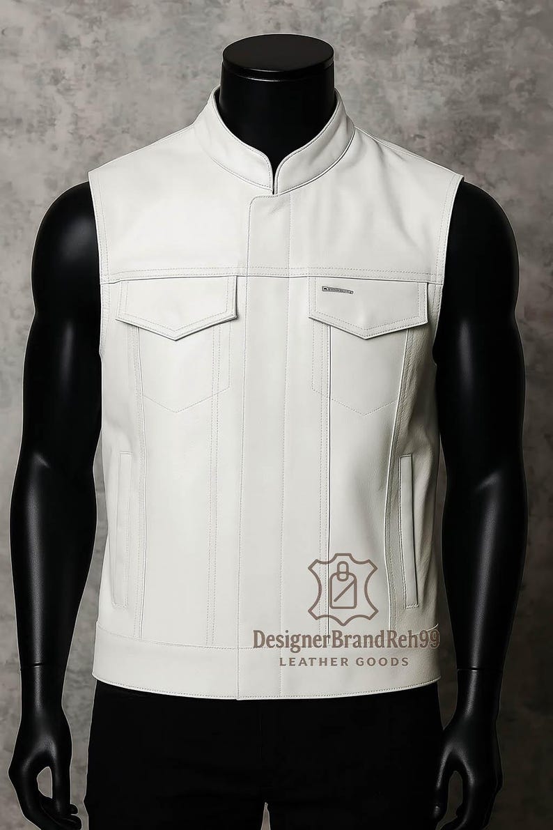 May include: White leather vest with a stand-up collar and two front pockets. The vest has a tailored fit and a minimalist design. The brand name "DesignerBrandReh99" and "LEATHER GOODS" are printed on the lower right side of the vest.