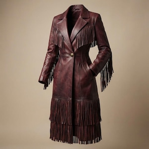 May include: A long, deep burgundy leather coat featuring a notched lapel, a single brass-toned button closure, and long fringe detailing across the chest, down the outer sleeves, and in two horizontal rows along the lower hem of the garment.