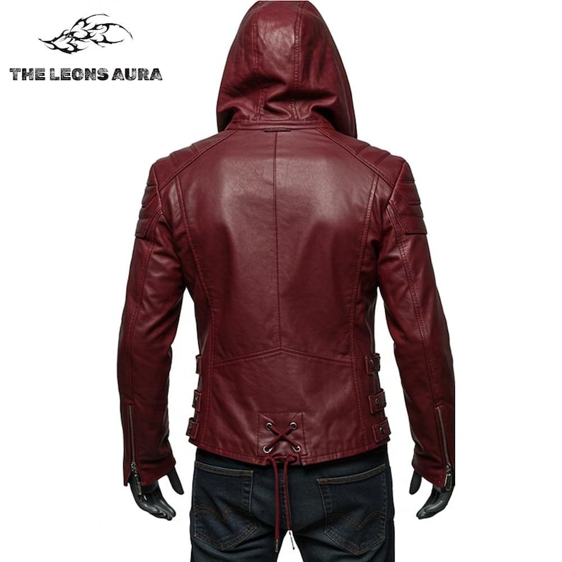 May include: Burgundy leather jacket with a hood, visible from the back. Features include a zipper closure, shoulder padding, and decorative buckles. The text "THE LEONS AURA" is visible in the upper left corner.